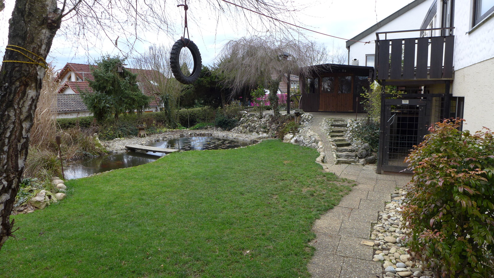 Schöner Garten auf der Rückseite eines Hauses mit Reifenschaukel